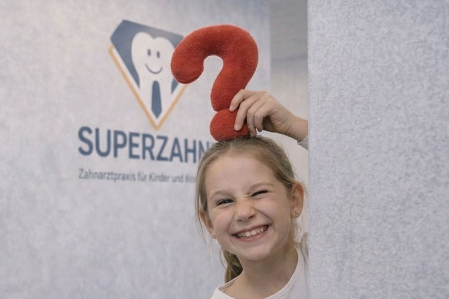 Kinderzahnarzt Unterföhring beantwortet Fragen eines Kindes spielerisch in der Praxis Superzahn